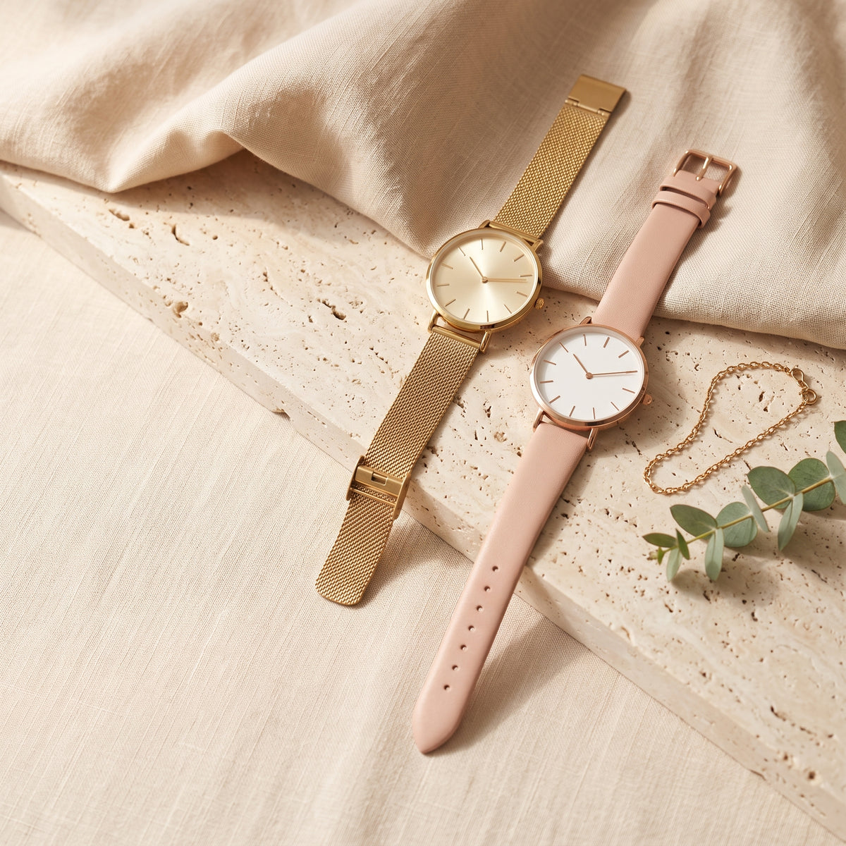 Women's gold and rose gold watches on beige linen and stone